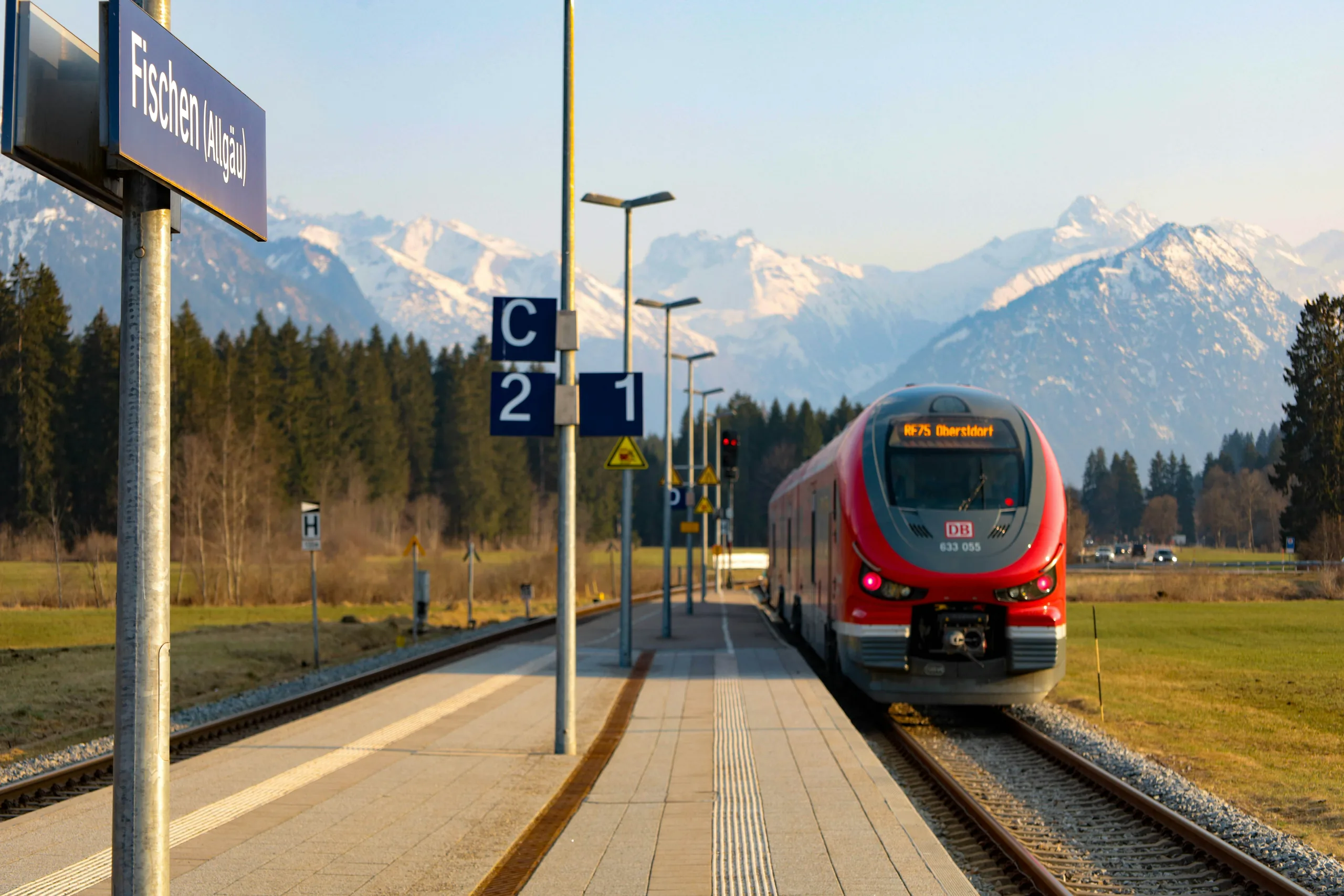 Regionalzug am Bahnsteig in Fischen im Allgäu vor Alpenpanorama – Einsatzgebiet der CG Safe Rail GmbH in Südbayern